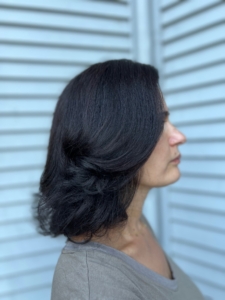 woman with dark hair after getting her fine hair cut and styled